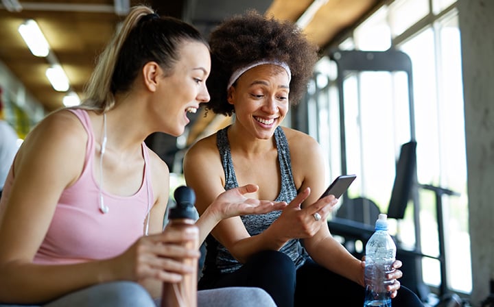 Two women looking a phone together in a gyn